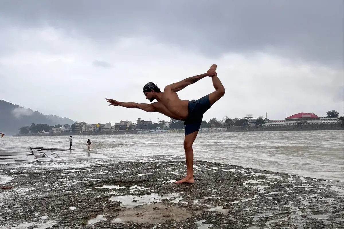 Yoga instructor providing personalized guidance to a student on a handstand pose.